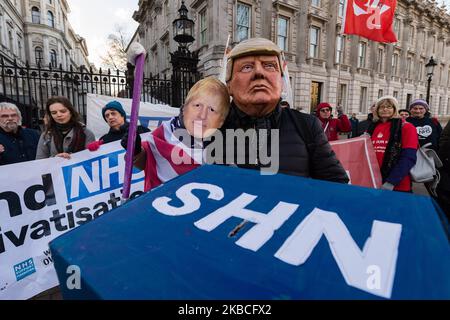 Demonstranten, die Masken von Donald Trump und Boris Johnson tragen, nehmen an einem Protest Teil, weil sie den National Health Service (NHS) außerhalb der Downing Street im Zentrum von London in öffentlicher Hand halten. Über 1 Millionen Menschen unterzeichneten am 09. Dezember 2019 in London, England, eine Petition, in der gefordert wird, dass der NHS von jeglichen Handelsabkommen nach dem Brexit ausgeschlossen wird. (Foto von Wiktor Szymanowicz/NurPhoto) Stockfoto