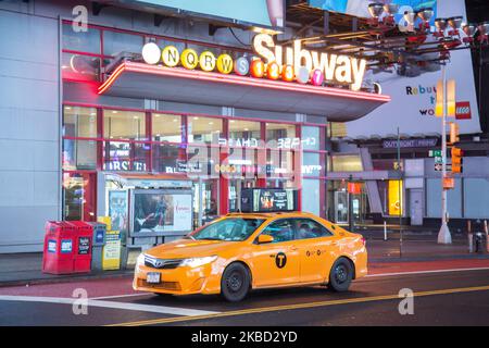 Ikonisches gelbes Taxi auf den Straßen von Midtown Manhattan, New York City nahe Times Square, 7. Ave und Broadway Avenue am 18. November 2019 in New York, USA. Beleuchtung und Nachtlichter des sich bewegenden Verkehrs von Fahrzeugen, Autos und stationären Taxis. (Foto von Nicolas Economou/NurPhoto) Stockfoto