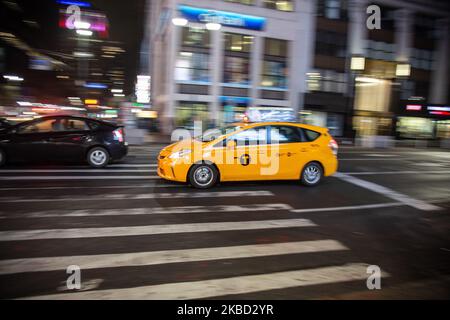 Ikonisches gelbes Taxi auf den Straßen von Midtown Manhattan, New York City nahe Times Square, 7. Ave und Broadway Avenue am 18. November 2019 in New York, USA. Beleuchtung und Nachtlichter des sich bewegenden Verkehrs von Fahrzeugen, Autos und stationären Taxis. (Foto von Nicolas Economou/NurPhoto) Stockfoto