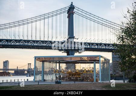 Am frühen Morgen Blick auf die ikonische Manhattan Bridge aus der Sicht des Dumbo Viertels in Brooklyn, NYC, USA am 14. November 2019. Die 448m. Lange Hängebrücke ist ein Wahrzeichen der Stadt New York, eine Touristenattraktion, die den East River überquert und Lower Manhattan mit der Innenstadt von Brooklyn verbindet. Die metallische Eisenbrücke ist aktiv mit Verkehr, 7 Fahrspuren und 4 Bahngleisen für die U-Bahn und Fahrräder. Es wurde 1909 von der Phoenix Bridge Company für den Verkehr geöffnet und von Leon Moisseiff entworfen. (Foto von Nicolas Economou/NurPhoto) Stockfoto