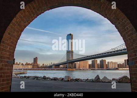 Am frühen Morgen Blick auf die ikonische Manhattan Bridge aus der Sicht des Dumbo Viertels in Brooklyn, NYC, USA am 14. November 2019. Die 448m. Lange Hängebrücke ist ein Wahrzeichen der Stadt New York, eine Touristenattraktion, die den East River überquert und Lower Manhattan mit der Innenstadt von Brooklyn verbindet. Die metallische Eisenbrücke ist aktiv mit Verkehr, 7 Fahrspuren und 4 Bahngleisen für die U-Bahn und Fahrräder. Es wurde 1909 von der Phoenix Bridge Company für den Verkehr geöffnet und von Leon Moisseiff entworfen. (Foto von Nicolas Economou/NurPhoto) Stockfoto