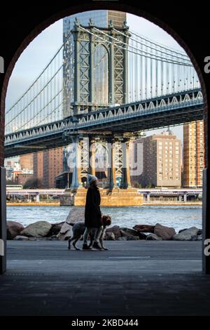 Am frühen Morgen Blick auf die ikonische Manhattan Bridge aus der Sicht des Dumbo Viertels in Brooklyn, NYC, USA am 14. November 2019. Die 448m. Lange Hängebrücke ist ein Wahrzeichen der Stadt New York, eine Touristenattraktion, die den East River überquert und Lower Manhattan mit der Innenstadt von Brooklyn verbindet. Die metallische Eisenbrücke ist aktiv mit Verkehr, 7 Fahrspuren und 4 Bahngleisen für die U-Bahn und Fahrräder. Es wurde 1909 von der Phoenix Bridge Company für den Verkehr geöffnet und von Leon Moisseiff entworfen. (Foto von Nicolas Economou/NurPhoto) Stockfoto