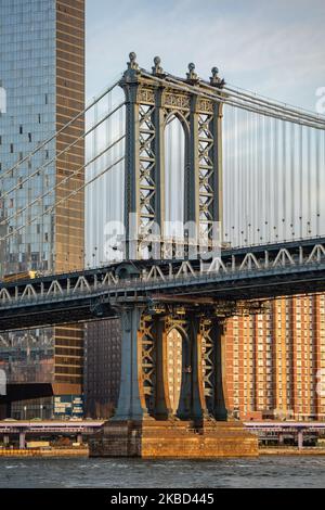 Am frühen Morgen Blick auf die ikonische Manhattan Bridge aus der Sicht des Dumbo Viertels in Brooklyn, NYC, USA am 14. November 2019. Die 448m. Lange Hängebrücke ist ein Wahrzeichen der Stadt New York, eine Touristenattraktion, die den East River überquert und Lower Manhattan mit der Innenstadt von Brooklyn verbindet. Die metallische Eisenbrücke ist aktiv mit Verkehr, 7 Fahrspuren und 4 Bahngleisen für die U-Bahn und Fahrräder. Es wurde 1909 von der Phoenix Bridge Company für den Verkehr geöffnet und von Leon Moisseiff entworfen. (Foto von Nicolas Economou/NurPhoto) Stockfoto