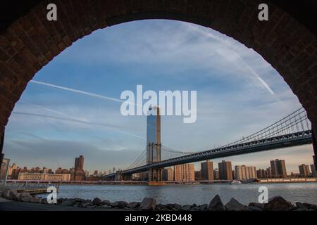 Am frühen Morgen Blick auf die ikonische Manhattan Bridge aus der Sicht des Dumbo Viertels in Brooklyn, NYC, USA am 14. November 2019. Die 448m. Lange Hängebrücke ist ein Wahrzeichen der Stadt New York, eine Touristenattraktion, die den East River überquert und Lower Manhattan mit der Innenstadt von Brooklyn verbindet. Die metallische Eisenbrücke ist aktiv mit Verkehr, 7 Fahrspuren und 4 Bahngleisen für die U-Bahn und Fahrräder. Es wurde 1909 von der Phoenix Bridge Company für den Verkehr geöffnet und von Leon Moisseiff entworfen. (Foto von Nicolas Economou/NurPhoto) Stockfoto