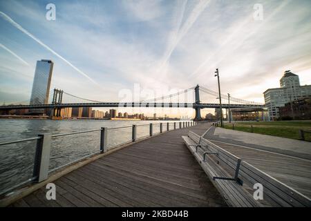 Am frühen Morgen Blick auf die ikonische Manhattan Bridge aus der Sicht des Dumbo Viertels in Brooklyn, NYC, USA am 14. November 2019. Die 448m. Lange Hängebrücke ist ein Wahrzeichen der Stadt New York, eine Touristenattraktion, die den East River überquert und Lower Manhattan mit der Innenstadt von Brooklyn verbindet. Die metallische Eisenbrücke ist aktiv mit Verkehr, 7 Fahrspuren und 4 Bahngleisen für die U-Bahn und Fahrräder. Es wurde 1909 von der Phoenix Bridge Company für den Verkehr geöffnet und von Leon Moisseiff entworfen. (Foto von Nicolas Economou/NurPhoto) Stockfoto