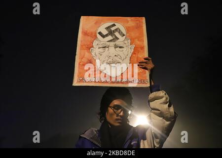 Ein Junge hält ein Plakat mit dem Bild des indischen Premierministers Narendra Modi während eines Protestes gegen den Citizenship Amendment Act (CAA) in Neu-Delhi, Indien, am 19. Dezember 2019 (Foto: Nasir Kachroo/NurPhoto) Stockfoto