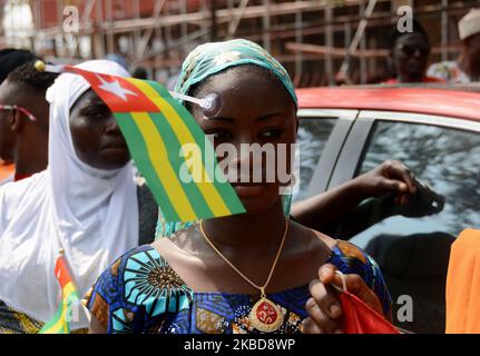 Ein togolesisches Mädchen Schnitt ihr während ihrer Proteste in Lagos, Nigeria, am 19. Dezember 2019 ihre Nationalflagge ins Gesicht. Togolesische Staatsbürger versammelten sich in Lagos, um gegen den Trick von Präsident Faure Gnassignbe zu protestieren, eine vierte Amtszeit zu führen, die das Land 20 Jahre lang regieren wird, nachdem er von seinem Vater, Gnassimgbe Eyadema for, 33 Jahre lang regierte. Das togolesische Volk wird dieses Jahr zum zweiten Mal in Lagos protestieren. Die fortgesetzte Herrschaft ihrer und seiner Wiederwahl-Ambitionen in Lagos. (Foto von Olukayode Jaiyeola/NurPhoto) Stockfoto