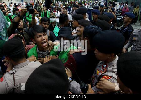 Während der Kundgebung zur Unterstützung der uigurischen muslimischen Minderheit sowie der Kritik an der chinesischen Regierung vor der chinesischen Botschaft in Jakarta am Freitag, dem 20. Dezember 2019, kollidieren Demonstranten mit der Polizei. Sie verurteilten die chinesische Regierung für ihre Verfolgung von Millionen von Uiguren und vor allem von Muslimen, indem sie sie sie in Gefangenenlager, von denen Peking behauptete, sie seien „Umerziehungslager“ zur Ausrottung des Terrorismus, in Chinas nordwestlicher Region Xinjiang, einbrachten. (Foto von Aditya Irawan/NurPhoto) Stockfoto