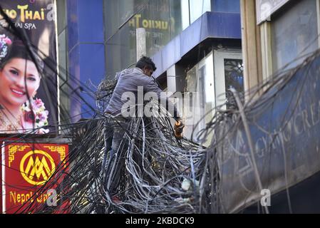 Mitarbeiter der Nepal Electricity Authority (NEA), die am Sonntag, den 22. Dezember 2019, die abgeballten Drähte und Kabel aus dem gesamten Gebiet um den Kern von Thamel, Kathmandu, Nepal, entfernen. NEA hat mit den Arbeiten zur Erdoberfläche von Stromleitungen begonnen. (Foto von Narayan Maharjan/NurPhoto) Stockfoto