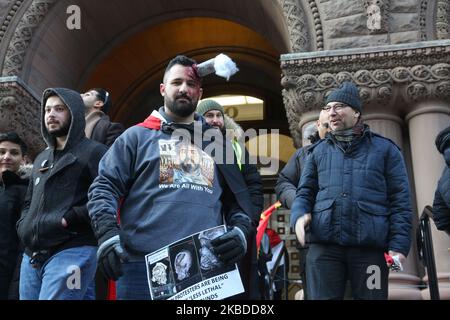 Protestierender mit einem verspotteten Tränengaskanister in seinem Kopf (als Protest gegen den tödlichen Einsatz von Tränengas, bei dem eine Person getötet und viele andere im Irak verletzt wurden) während einer Kundgebung zur Unterstützung irakischer Demonstranten im Old City Hall in Toronto, Ontario, Kanada, Am 21. Dezember 2019. Irakische Kanadier protestierten in der Innenstadt von Toronto, um die Gewalt gegen regierungsfeindliche Demonstranten im Irak anzuprangern. Mindestens 341 Demonstranten sind seit dem 1. Oktober 2019 bei massiven Protesten im Irak ums Leben gekommen und Tausende wurden verletzt. Irakische Sicherheitskräfte feuerten Gummigeschosse und Tränengas ab, um Menschenmengen in Bagdad, kil, zu zerstreuen Stockfoto