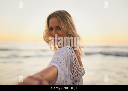 Das Leben ist besser, wenn man mit dem Fluss geht. Eine Frau lädt Sie ins Wasser ein. Stockfoto