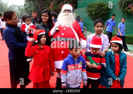 Kinder posieren für ein Gruppenfoto mit einem Mann, der als Weihnachtsmann gekleidet ist, während einer Weihnachtsfeier in der Hauptstadt Dhaka, Bangladesch, am 25. Dezember 2019 (Foto: Mamunur Rashid/NurPhoto) Stockfoto