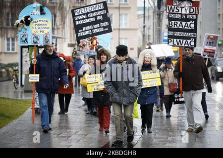 Während einer Demonstration in Warschau, Polen, am 23. Dezember 2019 gegen die plötzliche Suspendierung von Pawel Juszczyszyn, werden Demonstranten vor dem Obersten Gerichtshof vorgeführt. Juszczyszyn ist ein Richter aus Olsztyn in Nordpolen, der abrupt suspendiert wurde, nachdem er die Ernennung eines weiteren Richters durch den Nationalrat der Justiz (KRS) kritisiert hatte, der die Klagen gegen die Justiz überwacht und größtenteils unter politischer Kontrolle der aktuellen, euroskeptischen Partei für Recht und Gerechtigkeit steht. Die polnische Regierung wurde von der EU heftig kritisiert und gefährdet die Unabhängigkeit der Justiz und trotz allem Stockfoto