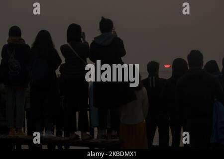 Am 01. Januar fotografieren die Menschen, wie die Sonne durch den smokeÂ aufgeht, von den australischen Buschfeuern, die über Neuseeland driften,Â am New Brighton Beach in Christchurch, Neuseeland, 2020.Â Buschfeuer in Australien spucken eine massive Rauchströmung über den Tasman in Richtung Neuseeland und es gibt auch einen Rauchgeruch in Teilen der Südinsel. (Foto von Sanka Vidanagama/NurPhoto) Stockfoto