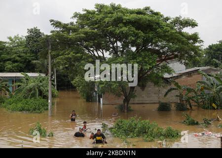 Die Bewohner überqueren die Überschwemmungen, die ihre Siedlungen überfluten, um am 1.. Januar 2020 in das Hochland im Cibitung Regency, West Java, zu fliehen. Der heftige Regen, der seit dem 31. Dezember 2019 mehr als 15 Stunden dauert, verursacht massive Überschwemmungen in der Hauptstadt Jakarta und in einigen Regionen und zwingt Tausende Einwohner zur Flucht. (Foto von Aditya Irawan/NurPhoto) Stockfoto