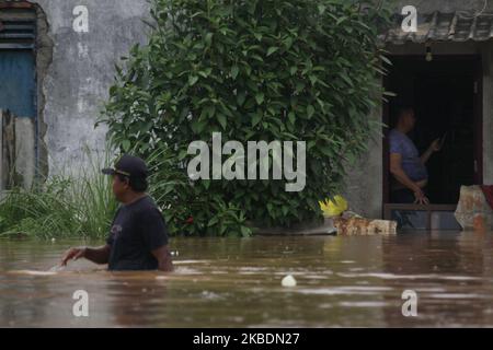 Die Bewohner überqueren die Überschwemmungen, die ihre Siedlungen überfluten, um am 1.. Januar 2020 in das Hochland im Cibitung Regency, West Java, zu fliehen. Der heftige Regen, der seit dem 31. Dezember 2019 mehr als 15 Stunden dauert, verursacht massive Überschwemmungen in der Hauptstadt Jakarta und in einigen Regionen und zwingt Tausende Einwohner zur Flucht. (Foto von Aditya Irawan/NurPhoto) Stockfoto