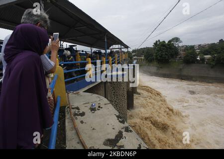 Am 1. Januar 2020 beobachteten mehrere Menschen den Anstieg des Wasserpegels des Ciliwung-Flusses im Katulampa-Staudamm in Bogor, West-Java. Starke Regenfälle, die die Region Bogor seit Dienstag (31. Dezember 2019) durchspülten, verursachten einen Anstieg des Wasserpegels im Katulampa-Staudamm und die Auswirkungen der Überschwemmungen in Jakarta. Nach Angaben der National Disaster Management Agency (BNPB) starben in Jakarta 9 Menschen und 19.709 Menschen wurden durch Überschwemmungen vertrieben. (Foto von Adriana Adie/NurPhoto) Stockfoto