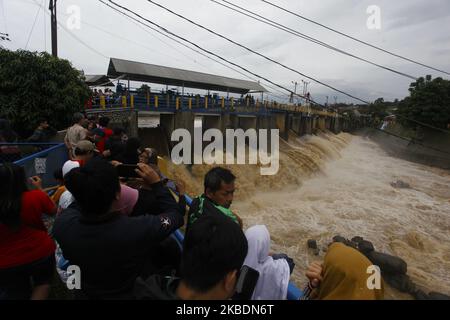 Am 1. Januar 2020 beobachteten mehrere Menschen den Anstieg des Wasserpegels des Ciliwung-Flusses im Katulampa-Staudamm in Bogor, West-Java. Starke Regenfälle, die die Region Bogor seit Dienstag (31. Dezember 2019) durchspülten, verursachten einen Anstieg des Wasserpegels im Katulampa-Staudamm und die Auswirkungen der Überschwemmungen in Jakarta. Nach Angaben der National Disaster Management Agency (BNPB) starben in Jakarta 9 Menschen und 19.709 Menschen wurden durch Überschwemmungen vertrieben. (Foto von Adriana Adie/NurPhoto) Stockfoto