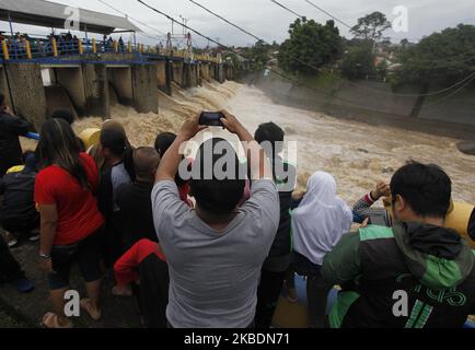 Am 1. Januar 2020 beobachteten mehrere Menschen den Anstieg des Wasserpegels des Ciliwung-Flusses im Katulampa-Staudamm in Bogor, West-Java. Starke Regenfälle, die die Region Bogor seit Dienstag (31. Dezember 2019) durchspülten, verursachten einen Anstieg des Wasserpegels im Katulampa-Staudamm und die Auswirkungen der Überschwemmungen in Jakarta. Nach Angaben der National Disaster Management Agency (BNPB) starben in Jakarta 9 Menschen und 19.709 Menschen wurden durch Überschwemmungen vertrieben. (Foto von Adriana Adie/NurPhoto) Stockfoto