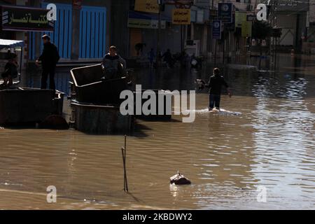 Palästinensische Kinder laufen am Sonntag, den 5. Januar 2020, durch Hochwasser nach heftigen Regenfällen in Jabaliya im nördlichen Gazastreifen. (Foto von Majdi Fathi/NurPhoto) Stockfoto