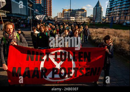 XR-Aktivisten gehen, während sie ein großes Banner halten und Klimaslogans während einer die-in-Aktion rufen, die von der XR-Gruppe in den Niederlanden am 6.. Januar 2020 im Zentrum von Rotterdam durchgeführt wurde. (Foto von Romy Arroyo Fernandez/NurPhoto) Stockfoto