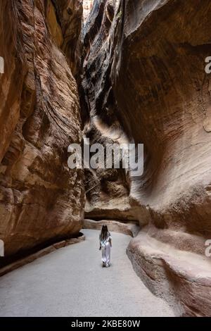 Petra, Jordanien - 27 2022. Oktober: Der Siq Gorge Eingang zur Nabatäischen Stadt Petra mit einem jungen Mädchen, das einen Keffiyeh Schal trägt. Stockfoto