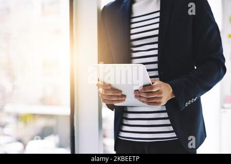 Sein Tablet ist eine Arbeitsmaschine. Ein Geschäftsmann, der in einem modernen Büro ein digitales Tablet benutzt. Stockfoto