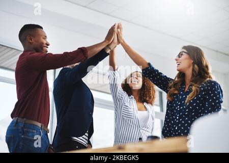 Kreativität führt zu Inspiration und Entschlossenheit, die zum Erfolg führt. Kreative Mitarbeiter feiern in einem modernen Büro. Stockfoto