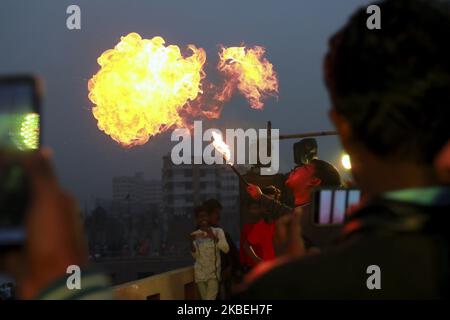 Die Bewohner des alten Dhaka spielen auf dem Dach ihres Gebäudes anlässlich des Shakrain-Festivals am 14. Januar 2019 in Dhaka, bangladesch, eine Feuerspaltung mit Kerosin-Öl. Das Shakrain-Festival fand in der Gegend von Gandaria in der alten Stadt Dhaka statt. Das Shakrain Festival, auch bekannt als Drachenfest, wird in Bangladesch am Ende des bangladeschischen Monats Poush gefeiert. Shakrain Festival ist eines der alten, berühmtesten und wichtigsten jährlichen Festivals in Bangladesch. Es ist das Symbol der Einheit und Freundschaft in Bangladesch. Shakrain Festival ist wichtig, vor allem für das Fliegen viele bunte Drachen, Feuer Stockfoto