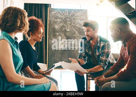 Für dieses Projekt brauchen wir alle Hands-on-Deck. Eine Gruppe von Designern, die in einem Büro diskutieren. Stockfoto