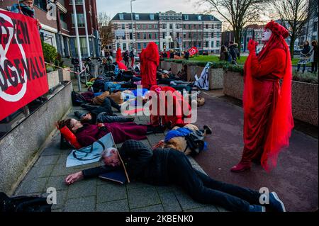 XR-Aktivisten und die Rote Rebellenbrigade führen während der zweiten Solidaritätsdemonstration der Extinction Rebellion mit Australien am 16.. Januar 2020 in Den Haag eine Einsterbeaktion durch. (Foto von Romy Arroyo Fernandez/NurPhoto) Stockfoto