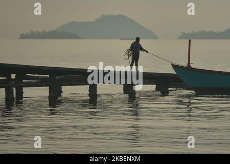 Ein Fischer kehrt bei Sonnenaufgang zu einem hölzernen Pier mit seinem Boot in Kep City zurück. Am Dienstag, Den 7. Januar 2020, Kep City, Kambodscha. (Foto von Artur Widak/NurPhoto) Stockfoto