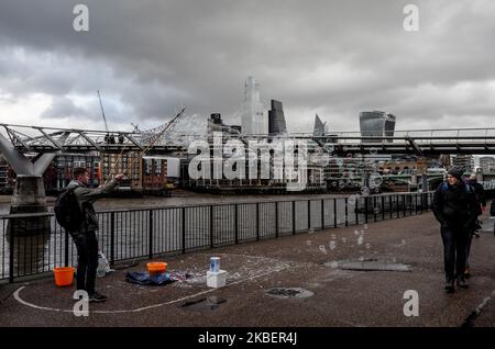 Ein Mann bläst Blasen, als am 17. Januar 2020 Menschen vor der Tate Modern Gallery am Südufer der Themse in London vorbei gehen. (Foto von Alberto Pezzali/NurPhoto) Stockfoto