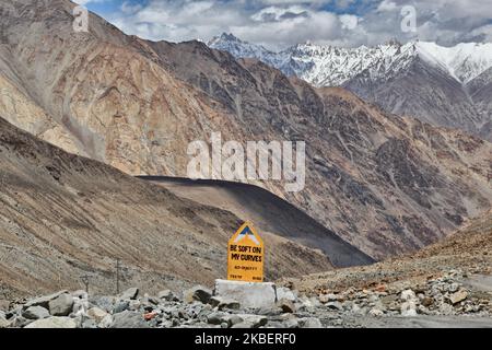 Am 5. Juli 2014 wurde auf einer kurvigen Bergstraße hoch im Himalaya in Durbuk, Ladakh, Jammu und Kaschmir, Indien, ein Straßenschild mit dem Titel „Seien Sie weich in meinen Kurven“ aufgestellt. (Foto von Creative Touch Imaging Ltd./NurPhoto) Stockfoto
