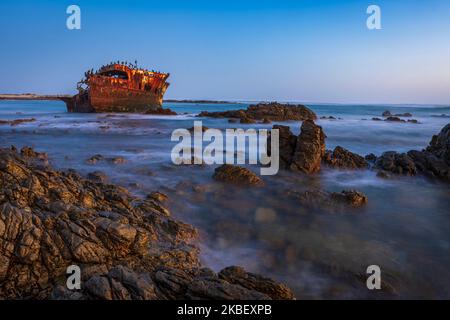 Ein Blick in die Dämmerung des Wracks der Meisho Maru Nr. 38, die Wellen und das Meer verschwimmen durch eine lange Belichtung, an der Küste von Cape Agulhas in der Nähe von L'Agulhas in Stockfoto