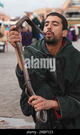 Schlangenbeschwörer küsst eine Kobra, während er am 5. Januar 2016 eine kleine Menge auf dem Platz Jemaa el-Fnaa in der Medina (Altstadt) von Marrakesch (Marrakesch) in Marokko, Afrika, unterhält. Marrakesch ist die viertgrößte Stadt im Königreich Marokko. (Foto von Creative Touch Imaging Ltd./NurPhoto) Stockfoto