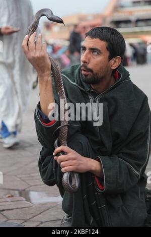 Schlangenbeschwörer hält eine Kobra, während er am 5. Januar 2016 eine kleine Menge auf dem Platz Jemaa el-Fnaa in der Medina (Altstadt) von Marrakesch (Marrakesch) in Marokko, Afrika, unterhält. Marrakesch ist die viertgrößte Stadt im Königreich Marokko. (Foto von Creative Touch Imaging Ltd./NurPhoto) Stockfoto