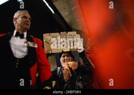 Anti-Waffenhandel-Aktivisten demonstrieren, als die Teilnehmer am 22. Januar 2020 zum jährlichen Black-Tie Dinner der Aerospace, Defence and Security Group im Grosvenor House Hotel an der Park Lane in London, England, eintreffen. Die ADS Group, eine Non-Profit-Organisation mit Sitz in London, vertritt und unterstützt mehr als 1.000 britische Unternehmen, die in den Bereichen Luft- und Raumfahrt, Verteidigung, Sicherheit und Raumfahrt tätig sind. Der Protest wurde von der Kampagne gegen Waffenhandel (CAAT) und Stop the Arms Fair Pressure-Gruppen einberufen, wobei insbesondere der Verkauf von britischen Waffen und Munitionsmaterial an Saudi-Arabien, das c Stockfoto