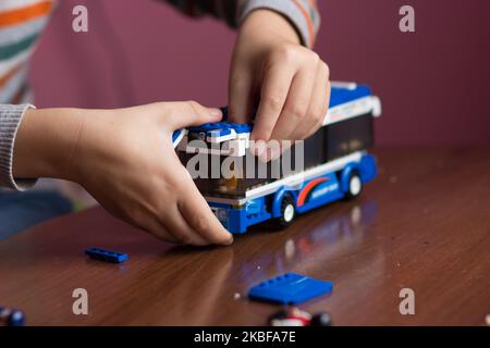 Junge Hand sammeln Designer auf Spielzeug Bus Bus Stockfoto