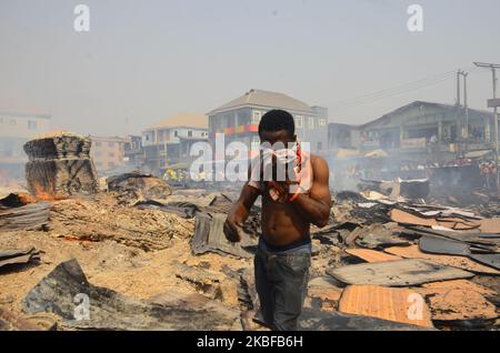 Ladenbesitzer retten auf dem beliebten Holzmarkt in Mushin, Lagos, am 25. Januar 2020 einige Überreste ihrer Habseligkeiten. Es wurden keine Verletzten gemeldet, und die Ursache des Feuers ist noch nicht bekannt. (Foto von Olukayode Jaiyeola/NurPhoto) Stockfoto