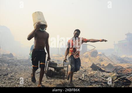 Ladenbesitzer retten auf dem beliebten Holzmarkt in Mushin, Lagos, am 25. Januar 2020 einige Überreste ihrer Habseligkeiten. Es wurden keine Verletzten gemeldet, und die Ursache des Feuers ist noch nicht bekannt. (Foto von Olukayode Jaiyeola/NurPhoto) Stockfoto