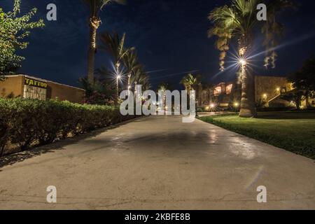 Pfad mit Palmen und wunderbaren Lichtern von einem Resort in ägypten in der Nacht Stockfoto