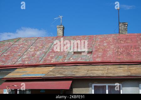 Reparieren Sie an einem sonnigen Tag das alte rostige Dach Stockfoto