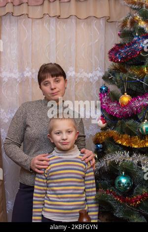 Mutter und Sohn in der Nähe von Weihnachtsbaum stehen Stockfoto