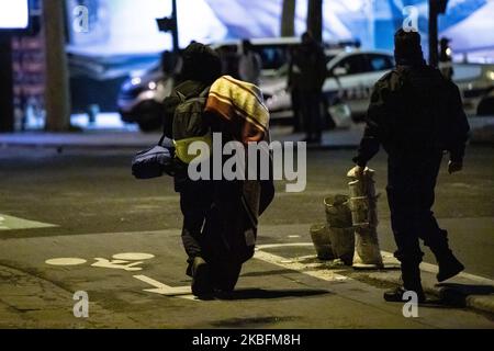 Von der Polizei verschleerte Migranten gehen mit seiner Tasche und seinem Eigentum in den leeren Zelten in Paris, Frankreich, am on28. Januar 2020. Evakuierung und Demontage der an der Porte d'Aubervilliers aufgesetzten Flüchtlingslager. Die Pariser Polizeipräfektur kündigt an, dass dieser Operation die Unterbringung und Unterbringung der Evakuierten folgen wird. (Foto von Jerome Gilles/NurPhoto) Stockfoto