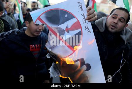 Ein palästinensischer Demonstranten verbrennt ein Bild, das US-Präsident Donald Trump während eines Protestes vor der Ankündigung Trumps seines lang verzögerten Friedensplans in Gaza City am 28. Januar 2020 darstellt. (Foto von Majdi Fathi/NurPhoto) Stockfoto