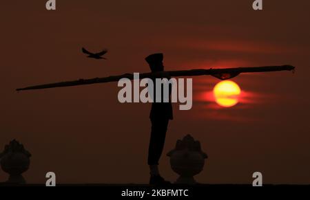 Die Sonne geht unter, während ein Sri-lankischer Soldat die Sri-lankische Nationalflagge trägt, nachdem sie am 28. Januar 2020 in Galle Face Green, Colombo, Sri Lanka, gesenkt wurde. (Foto von Tharaka Basnayaka/NurPhoto) Stockfoto