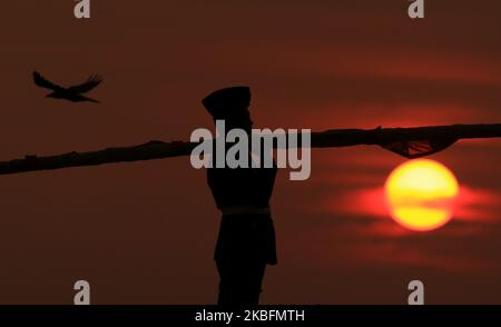 Die Sonne geht unter, während ein Sri-lankischer Soldat die Sri-lankische Nationalflagge trägt, nachdem sie am 28. Januar 2020 in Galle Face Green, Colombo, Sri Lanka, gesenkt wurde. (Foto von Tharaka Basnayaka/NurPhoto) Stockfoto