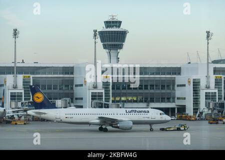 Ein Lufthansa Airbus A320 mit der Registrierung D-AIZF vor dem Terminal und Kontrollturm des Münchner Flughafens. Am frühen Morgen Flugverkehr Bewegung von Lufthansa-Flugzeugen mit ihrem Logo auf der Asphalt sichtbar und angedockt über Jetbridge oder Luftbrücke am Terminal am internationalen Flughafen München MUC EDDM in Bayern, Deutschland, Flughafen München. Die Deutsche Lufthansa DLH LH ist die Flaggonfluggesellschaft und größte Airline in Deutschland, die München als einen ihrer beiden Drehkreuze nutzt. Lufthansa ist Mitglied der Luftfahrtallianz Star Alliance. 26. Januar 2020 (Foto von Nicolas Economou/NurPhoto) Stockfoto