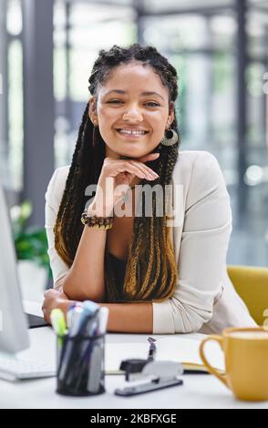 Ich bin die richtige Frau für den Job. Ein Porträt einer attraktiven jungen Geschäftsfrau, die im Büro an ihrem Schreibtisch sitzt. Stockfoto